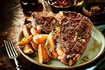 Thick juicy T-bone steak with spicy potato wedges