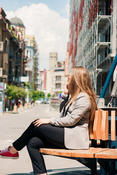 Girl Talking On Mobile Phone While Sitting On The Bench