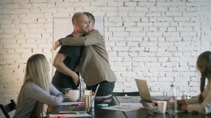 Business team is greeting their colleague in office before presentation. Co-workers are meeting in business office