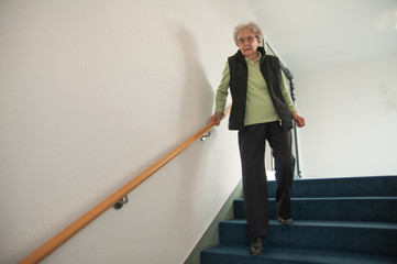 Seniorin geht die Treppe runter
