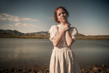 Fototapeta na wymiar Beautiful young blond woman outdoors portrait near the lake
