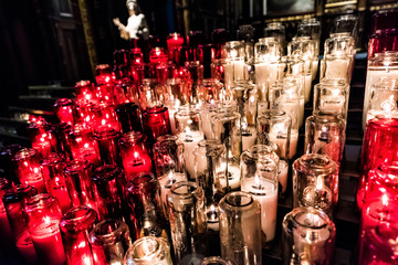 Red and white votive candles with yellow flame in church