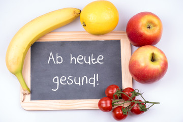 Ab heute gesund auf einer Tafel mit Obst und Gemüse