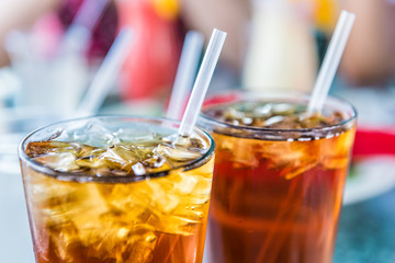 Macro closeup of iced tea or soda with ice cubes and straw in glass - Powered by Adobe