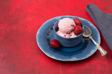 Homemade Strawberry Ice Cream in a Blue Bowl against a Red Background