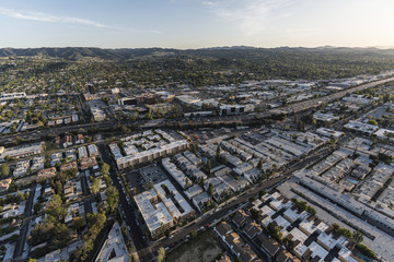 Aerial view of Ventura 101 Freeway, apartment rooftops and the Santa Monica Mountains in the San Fernando Valley area of Los Angeles, California.