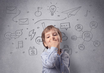 Smart little junior in front of a drawn up grey wall with childlike concept