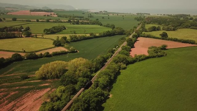 Aerial of West Somerset Railway locomotive driving through English landscape