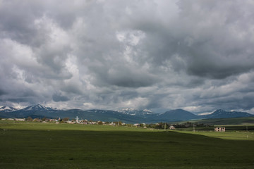 Fototapeta na wymiar village, mountains and grey clouds