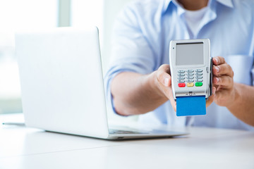 Man processing credit card transaction with POS terminal