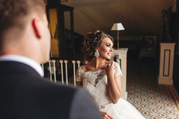 the groom admires the bride. Bride smiling looking out the window