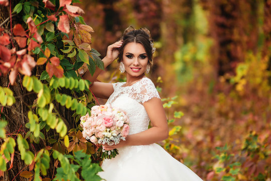 portrait of a smiling bride against the background of an autumn forest. Colorful nature