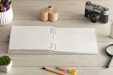 Empty notebook on wood floor with office tools nearby