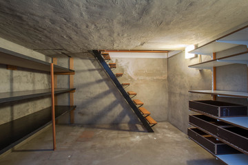 empty basement in abandoned old industrial building with little light and a wooden stairs - obrazy, fototapety, plakaty