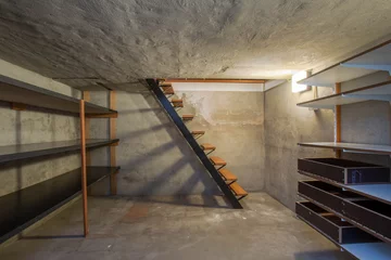 Fotobehang empty basement in abandoned old industrial building with little light and a wooden stairs © annebel146