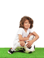 Boy with soccer ball on the green grass.