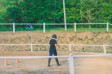 The female trainer is training the young horse for the tame in r