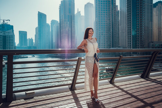 Happy beautiful unrecognizable tourist woman in fashionable summer white dress