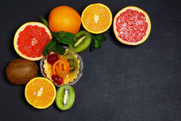 Variety of fruits grapefruit, oranges, kiwi, lemon, mint bunched together on a shale board, the concept of healthy eating, copy space, top view set