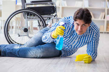 Disabled man on wheelchair cleaning home