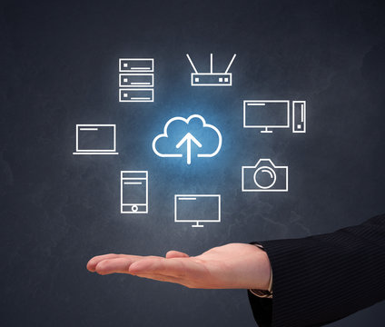 Cloud and computing related icons hovering over young hand 