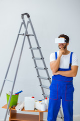 Man with VR glasses gluing wallpaper