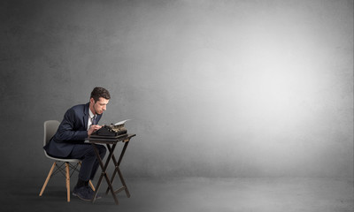 Man working hard on a typewriter in an empty space
