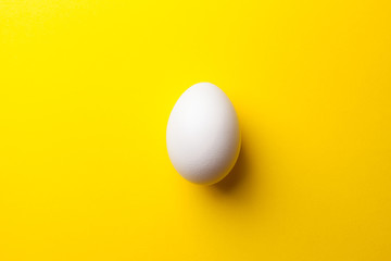 white egg on a yellow background