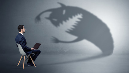 Young businessman staying and  negotiate with a monster shadow
