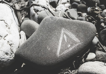 Warning sign scratched on a boulder stone