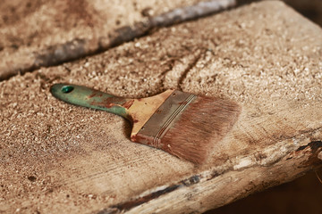 dirty used paint brushe on the background of wooden boards with sawdust. selective focus