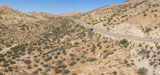 Quiet empty road borders the vast wilderness of the Mojave desert in the southwest of United States.