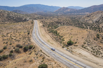 Single car on empty wilderness road in the Mojave Desert of southern California.