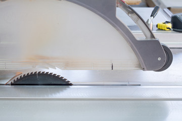 Industrial circular saw and vertical cutter in workshop.