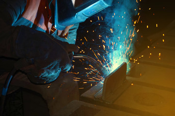 Welder at work for close-up work, joining parts with welding.