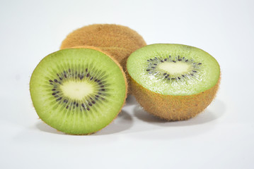 Half spiced kiwi with bright green kiwi isolated on white background