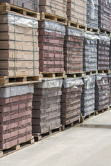 pallets with bricks in the building store. Racks with brick. Masonry, stonework. Several pallets with concrete brick stacked on top of each other in depot. new bricks on pallets