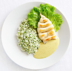 fried calamari garnished with rice and green herbs mix  and served with curry sauce 