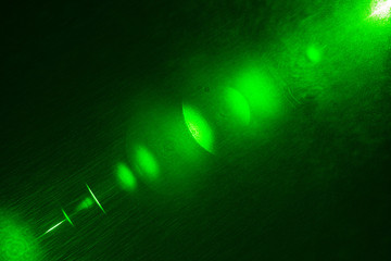 Camera lens flare by laser light create hexagons of objective iris shapes of number depending on number of lens surface and interference effect and moire on digital sensor on dark black background