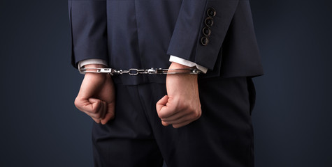 Close now arrested men hand with dark background and handcuffs
