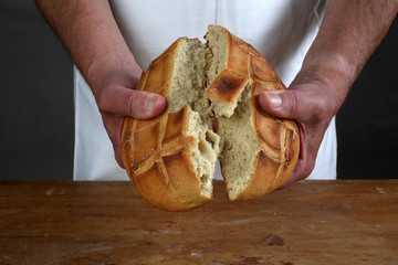Breaking of a fresh loaf of Eucharistic bread 