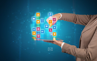 Female elegant hand holding tablet with colourful application icons