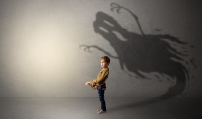 Scary ghost shadow in a dark empty room with a cute blond child
