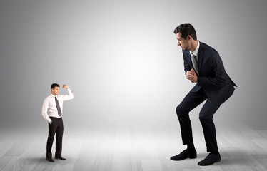 Big debutant young businessman scared of small strong businessman
