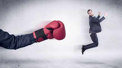 Huge Boxing Gloves punches innocent businessman concept
