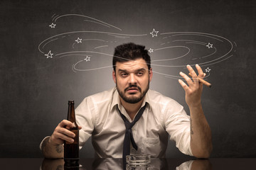 Young drunk man at his office with doodles around
