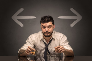 Drunk disappointed man sitting at table with arrows around
