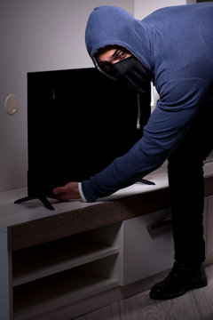 Burglar thief stealing tv from apartment house