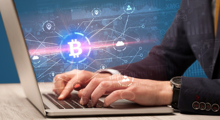 Hand checking on laptop global bitcoin exchange rate concept
