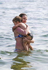 Mom with a small son in the sea on the beach.